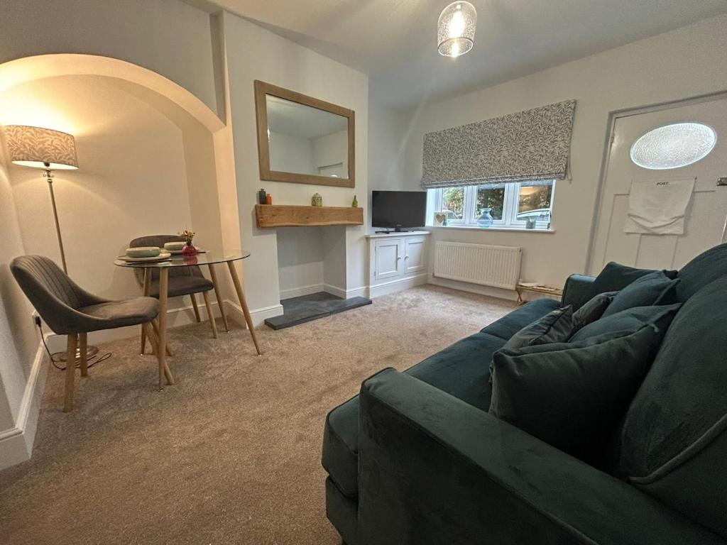 a living room with a blue couch and a table at 2 bedroom cosy home in Nantwich