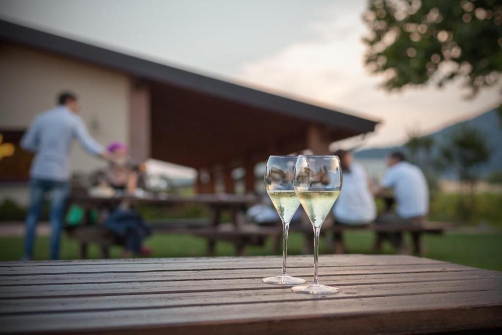 due bicchieri di vino bianco seduti su un tavolo di legno di Cascina Clarabella a Iseo