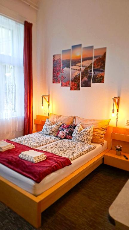 a bedroom with a bed with paintings on the wall at GoodMo Budapest Smart Rooms in Budapest