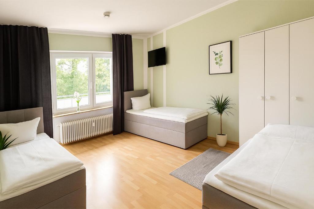 ein Schlafzimmer mit zwei Betten und einem Fenster in der Unterkunft SUNNYHOME Monteurwohnungen und Apartments in Weiden in Weiden
