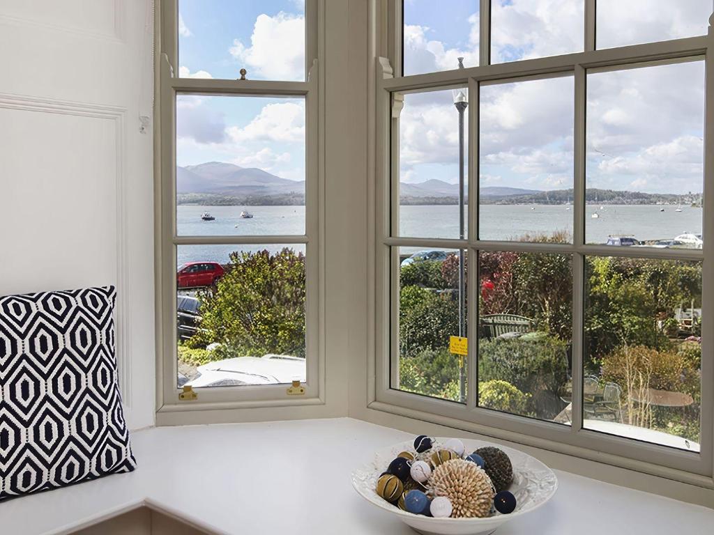 a bowl of shells on a counter in front of windows at Tri Raglan Mawr in Beaumaris