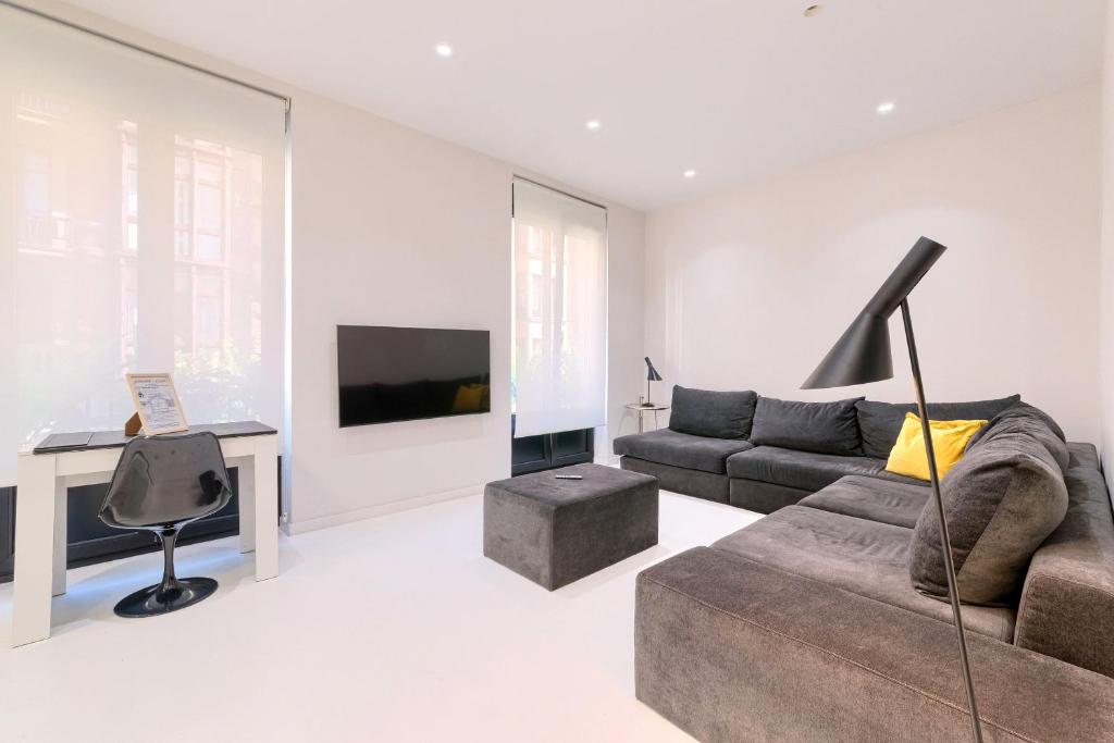 a white living room with a couch and a desk at Apartamento Bilbo in Bilbao