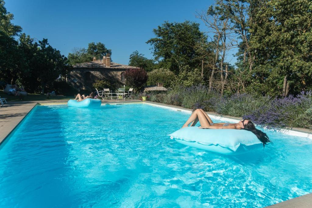 a woman laying on an infogie board in a swimming pool at Collina Blu - Umbria - Lago di Bolsena in Bolsena