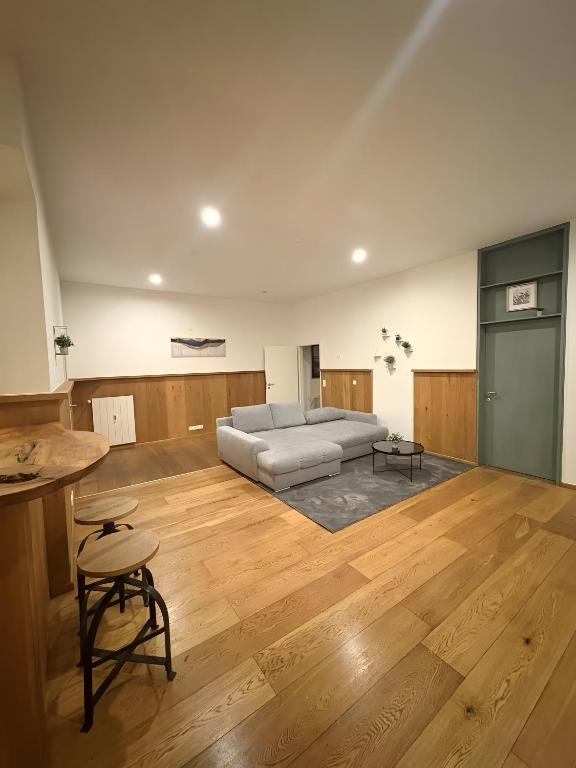 a living room with a couch and a wooden floor at Ferienwohnung C und D in Oberthulba