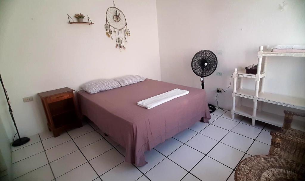 a bedroom with a pink bed and a fan at Casa Andrea in Flores