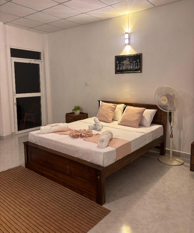 a bedroom with a large bed with a fan at The Kandy Look Homestay in Kandy