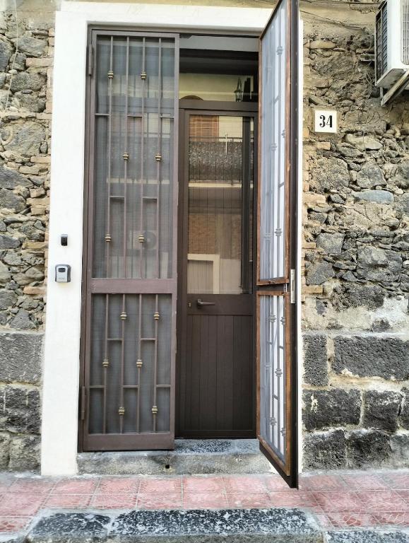 a door to a house with a stone wall at Vacanze a 2 passi dal mare in Giardini Naxos