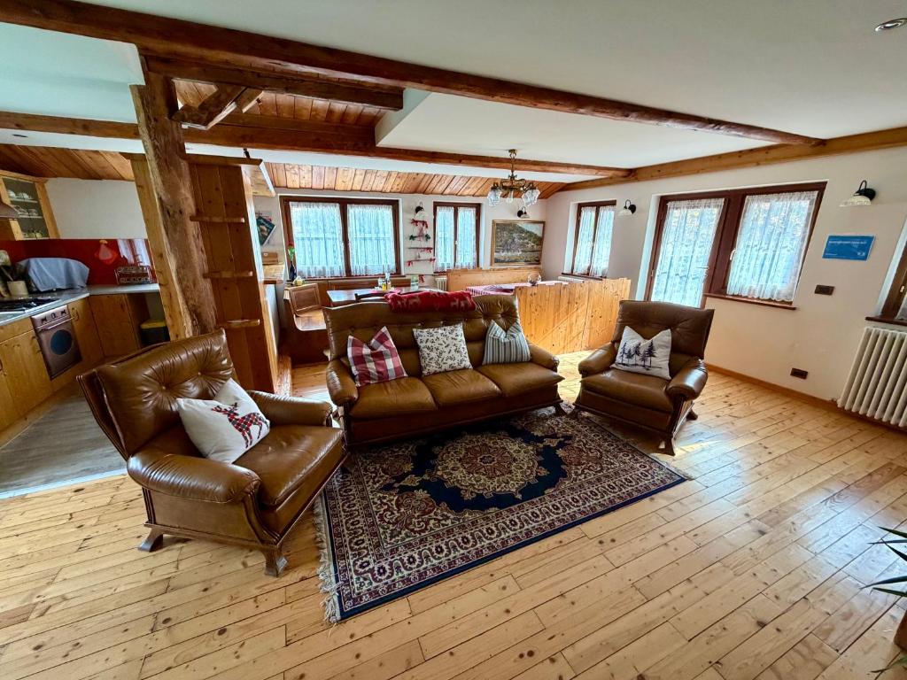 een woonkamer met leren banken en een tapijt bij AGRITURISMO FARE BIO in Tarvisio