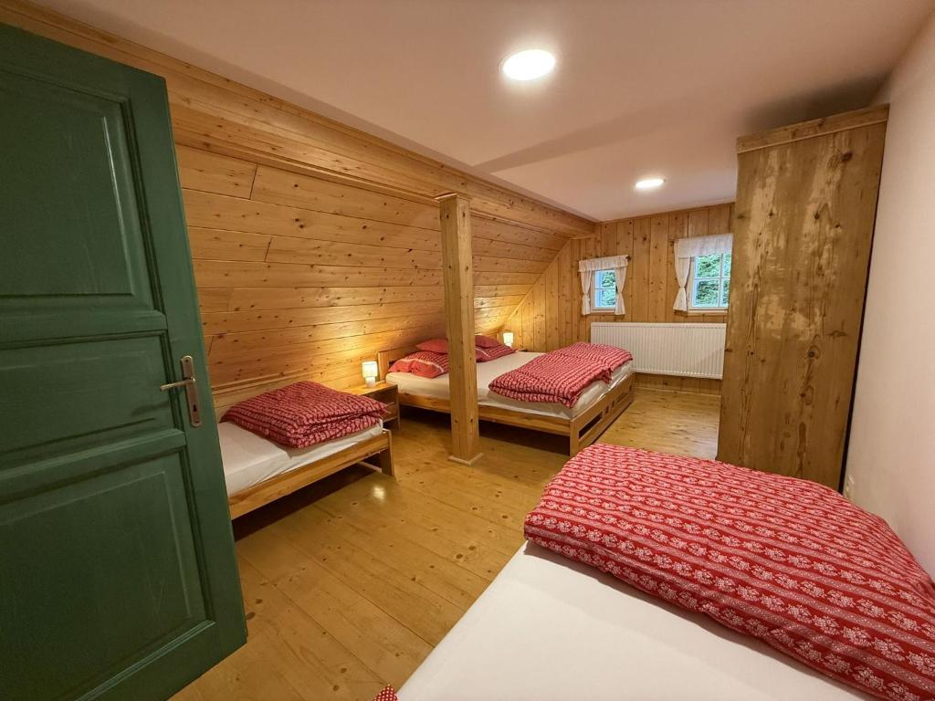a room with two beds in a log cabin at Chalupa Nikolka in Dolni Dvur