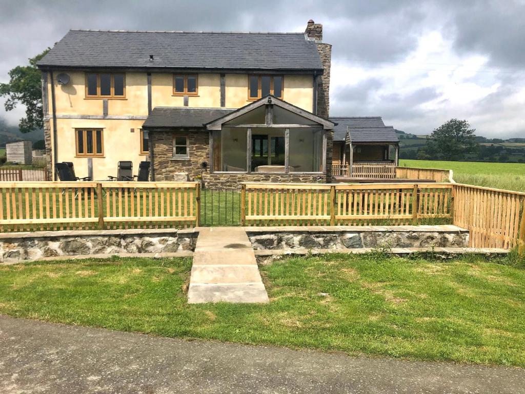 a house with a wooden fence in front of it at Upper Close - Uk10873 in Evenjobb