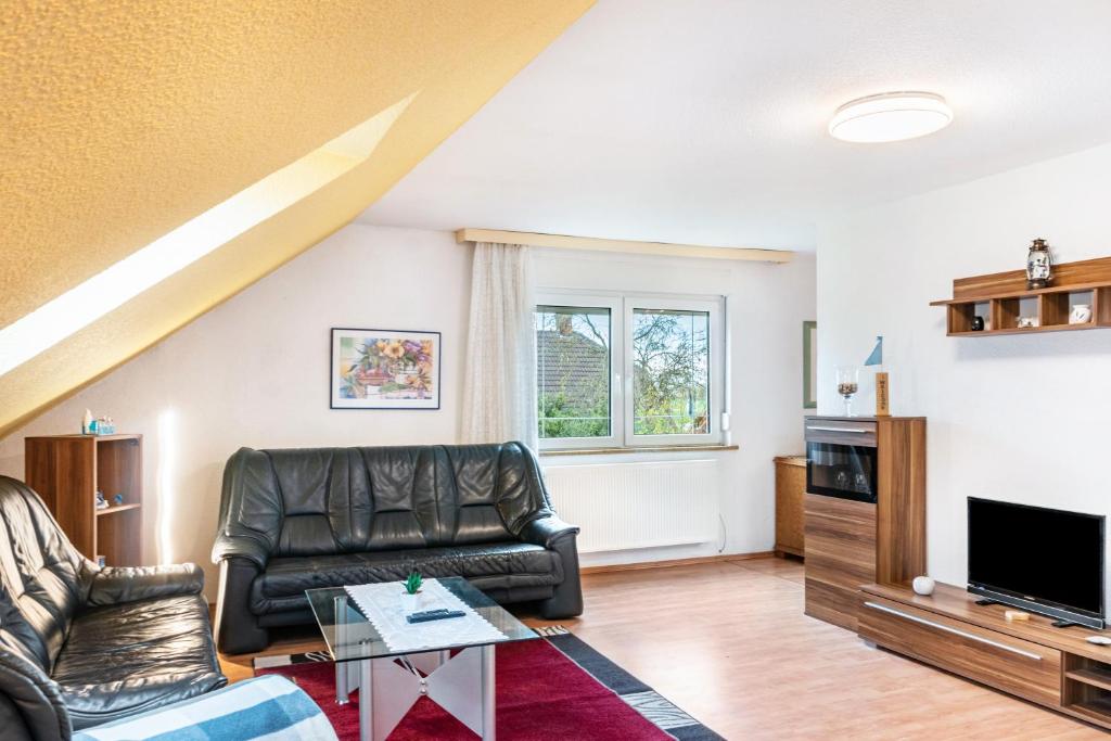 a living room with a couch and a tv at Fewo Wilhelmshaven Langewerth in Roffhausen