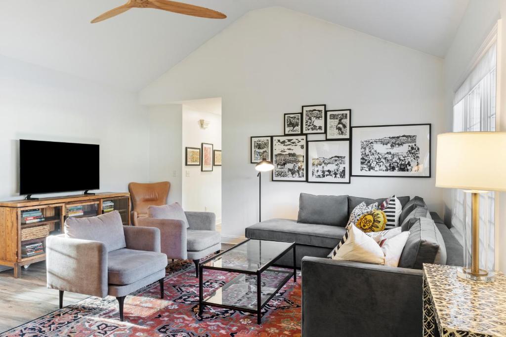a living room with a couch and chairs and a tv at The Clover Cottage in Normaltown in Athens