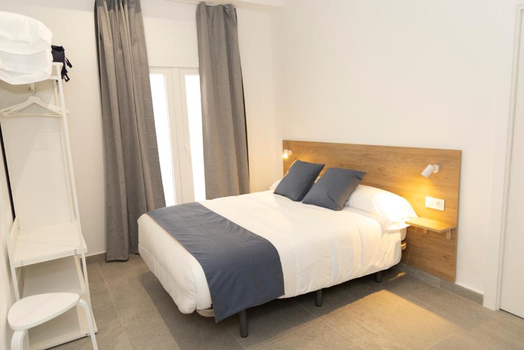 a bedroom with a bed and a book shelf at UVA Apartamentos in Badajoz