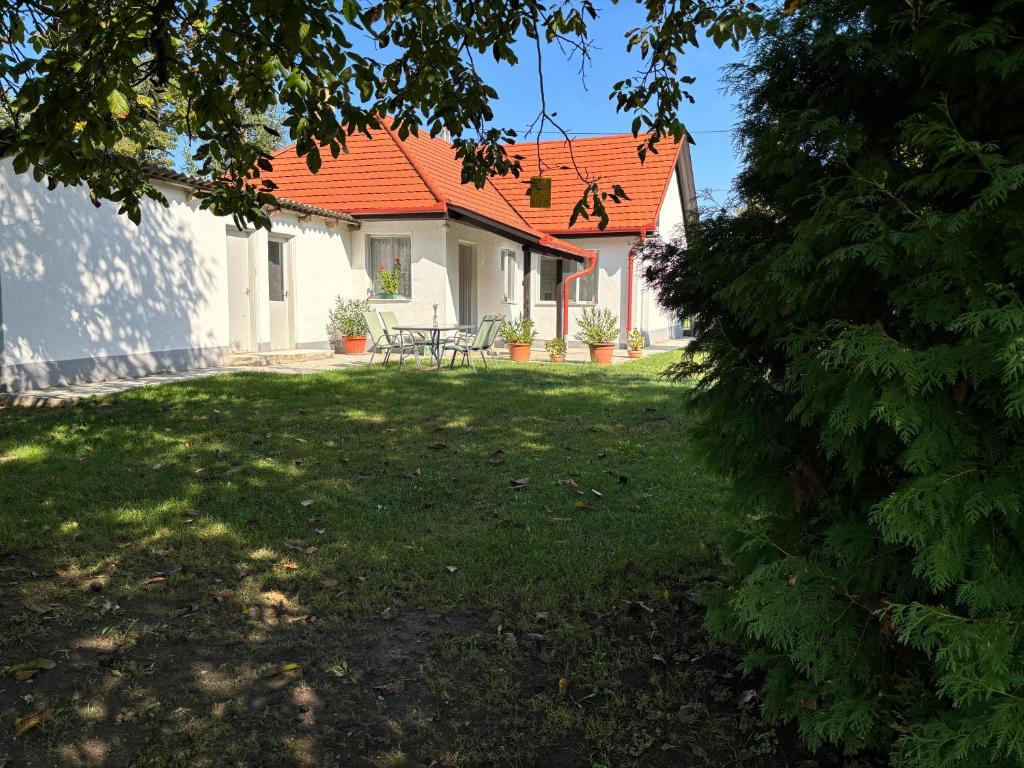a house with an orange roof and a yard at Gólyafészek Vendégház in Szécsény