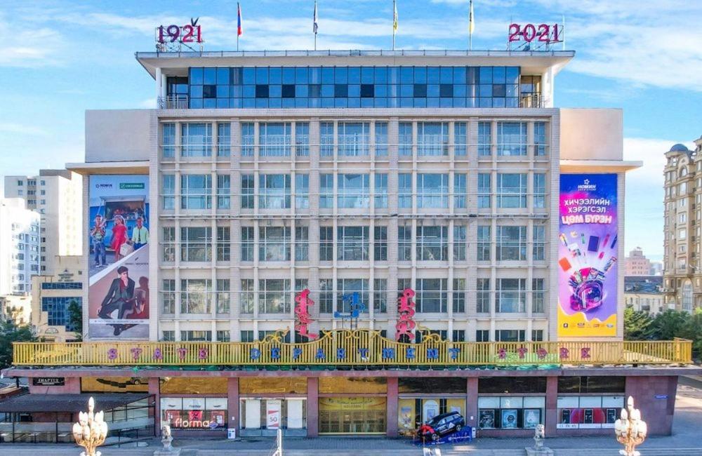 ein großes Gebäude mit Schildern an der Seite in der Unterkunft Tsese in Ulaanbaatar