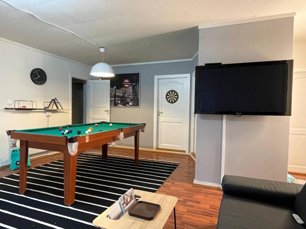 ein Wohnzimmer mit einem Billardtisch und einem Flachbild-TV in der Unterkunft Stavanger BnB 15 Central Apartment with Private Sauna Billiards in Stavanger
