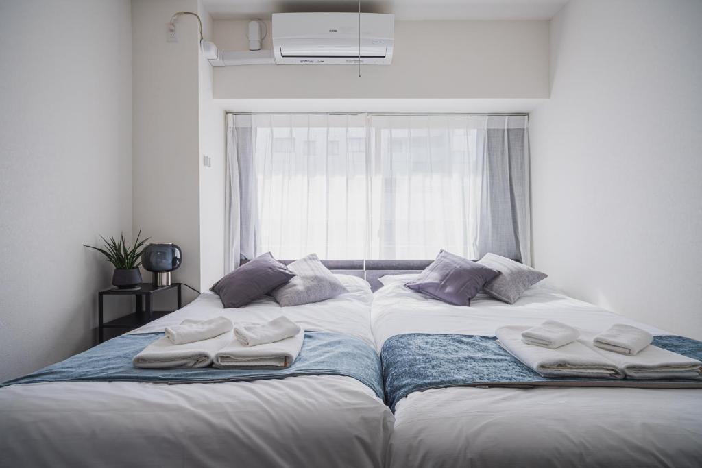 東京にあるERIKO HOTEL Azabujubanの部屋にはタオルが敷かれたベッドが2つある