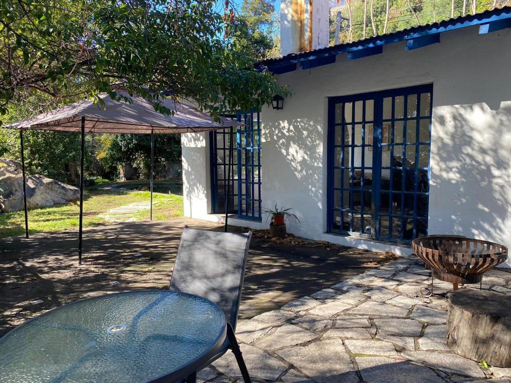 a table and an umbrella in front of a house at Glamping, Piscina, Río y Bosque - Más Líderes Experiencias in Santiago