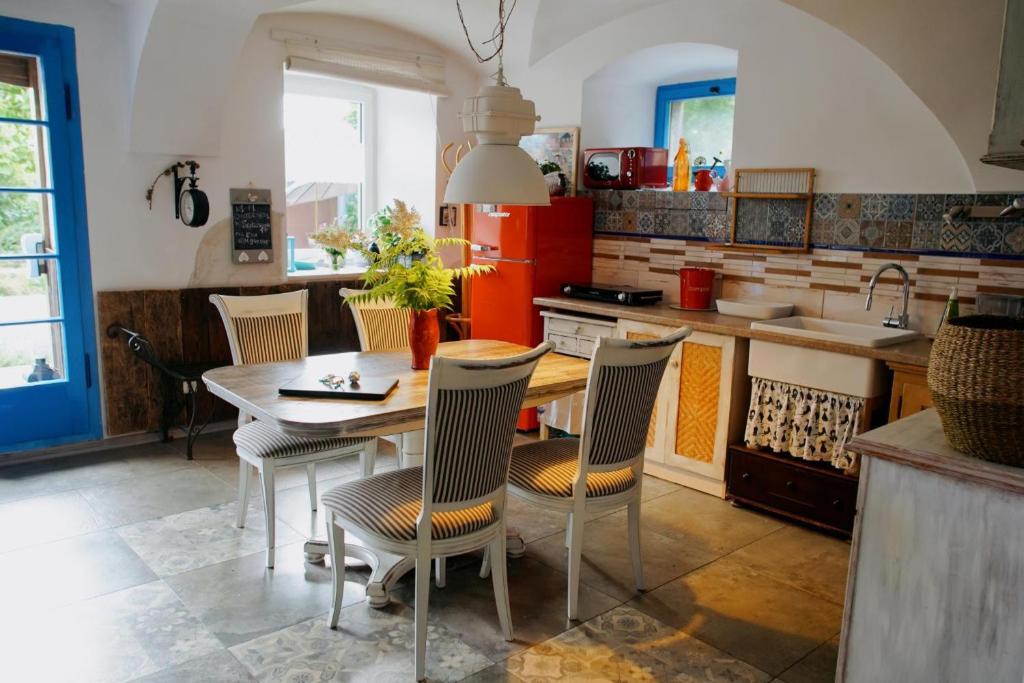 a kitchen with a table and chairs and a kitchen with a sink at Agroturystyka "Polna 17" Piętro I Stajnia in Sędziszowa