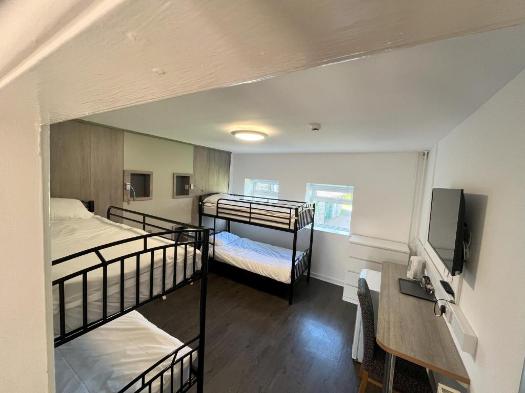 アバーデアにあるDare Valley Accommodation and Campsiteの二段ベッド2台、デスクが備わる客室です。