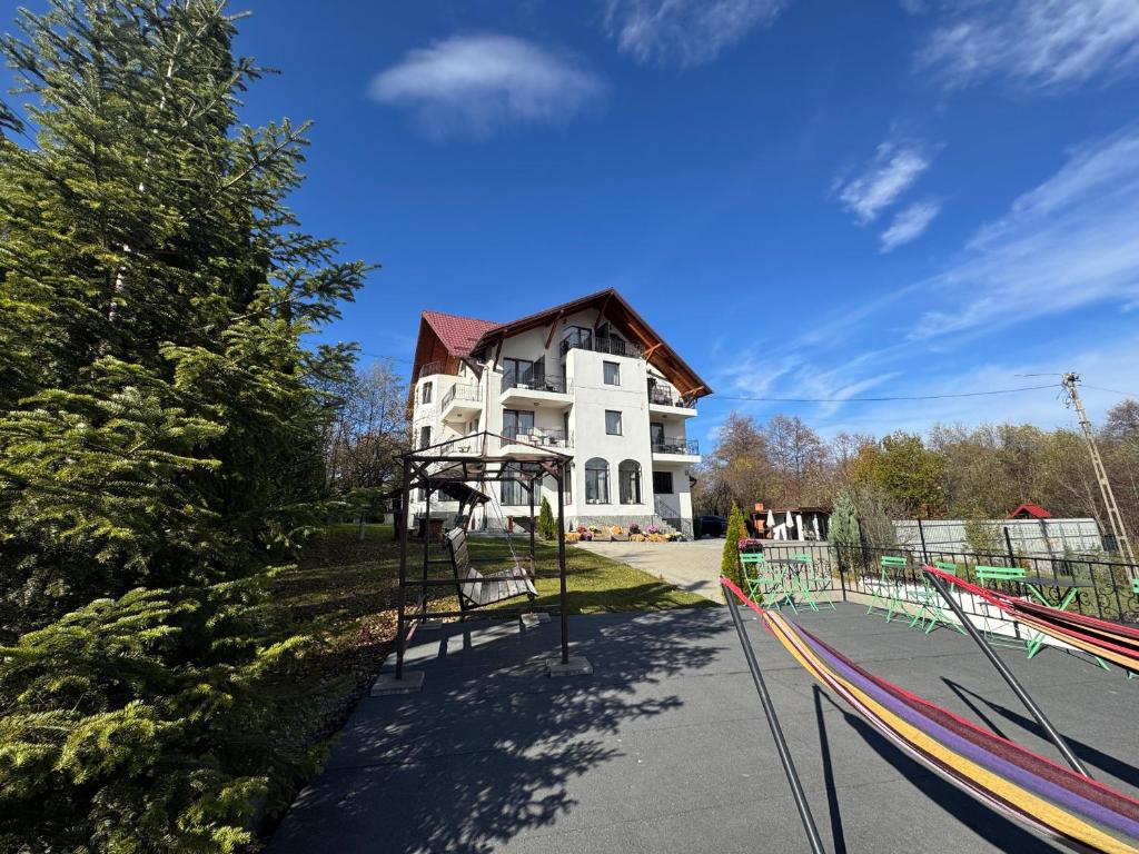 a white house with a playground in front of it at Oana Boutique C D I in Bran