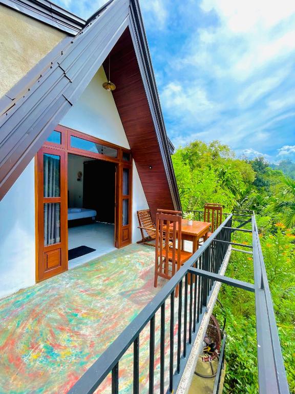 a balcony of a house with a table and chairs at New Arch Heaven Ella in Ella