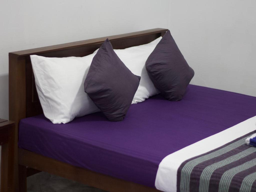 two pillows on a bed with purple and white sheets at Cozy Space - Madiha in Matara