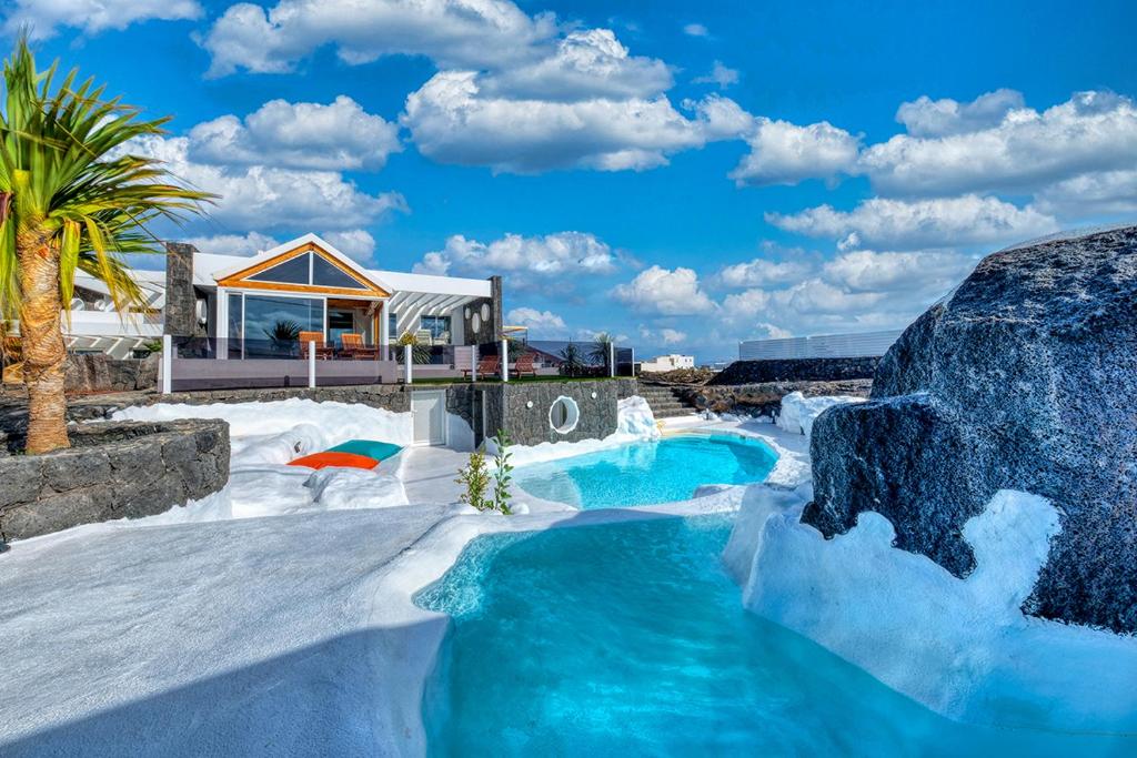 a house with a pool in the snow at Chalet Cueva del Sol in Tahiche