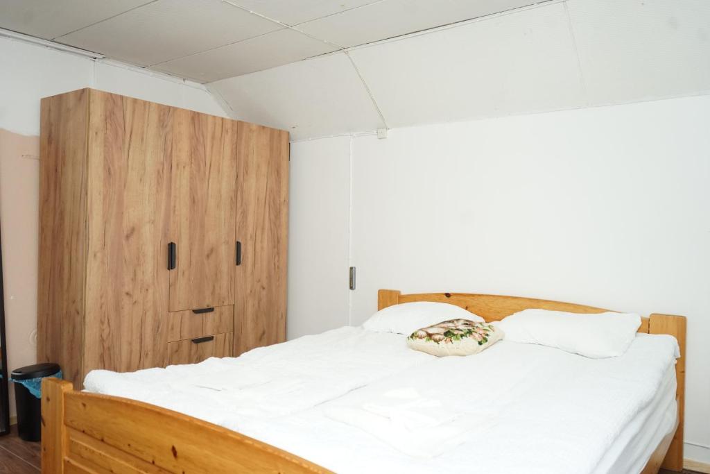 um quarto com uma cama e um armário de madeira em Upstairs include bedroom, and living room em Hyvinkää