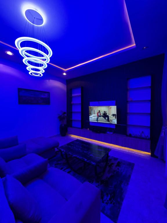 a blue living room with a couch and a tv at Hideout in Ankuru