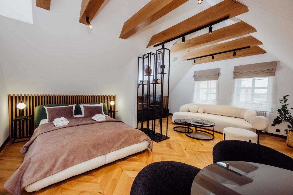 a bedroom with a large bed and a couch at Grodzka Boutique Aparthotel - Stare Miasto in Jelenia Góra