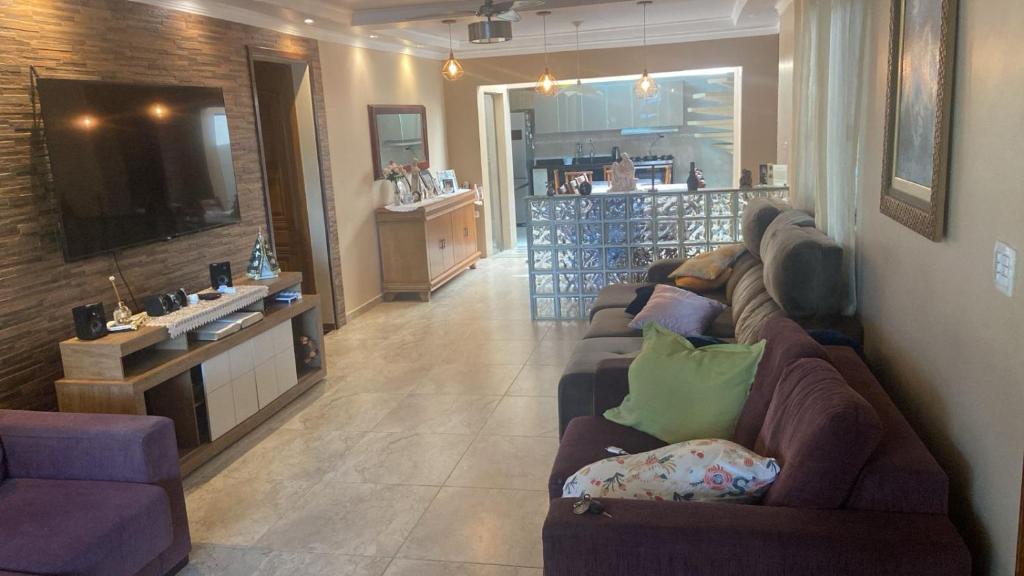 a living room with a couch and a television at Casa Mar in Guaratuba