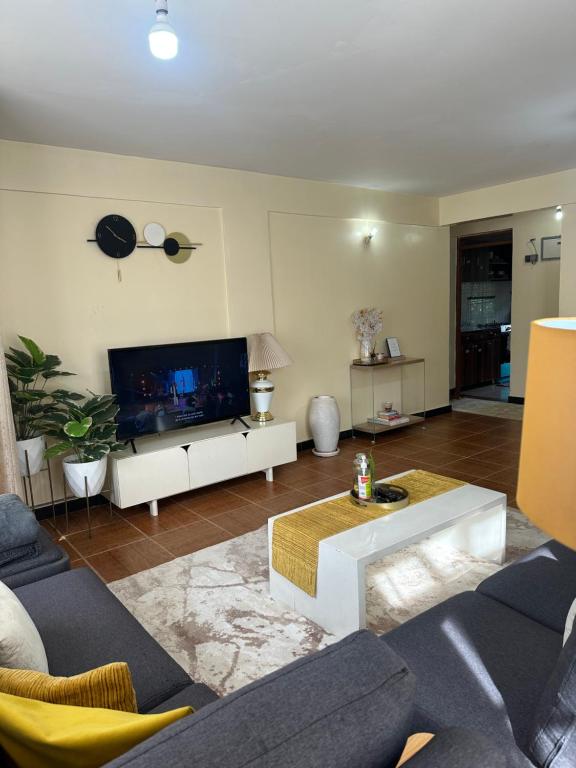 a living room with a couch and a tv at Eden Space Accommodations in Nairobi