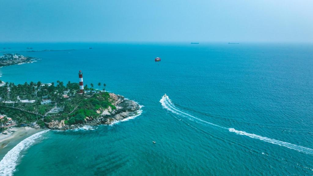 une vue aérienne sur un phare d'une île dans l'océan dans l'établissement The Travancore Palace Beach Resort, à Kovalam