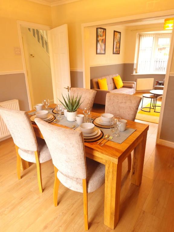 a wooden table with chairs and a dining room at Bright & cosy 3-bed semi in Wheatley, Doncaster in Arksey