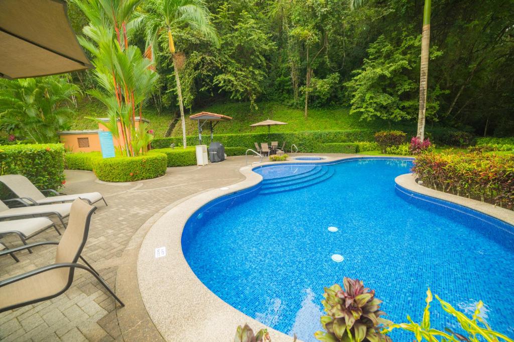 a swimming pool in a yard with chairs and trees at Veranda 8H 3 bdr Garden View in Los Suenos in Herradura
