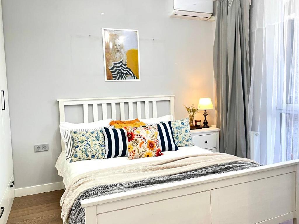 ein weißes Bett mit Kissen darauf im Schlafzimmer in der Unterkunft Terra с шикарным видом на горы, рядом ТРЦ Mega по розыбакиева in Almaty