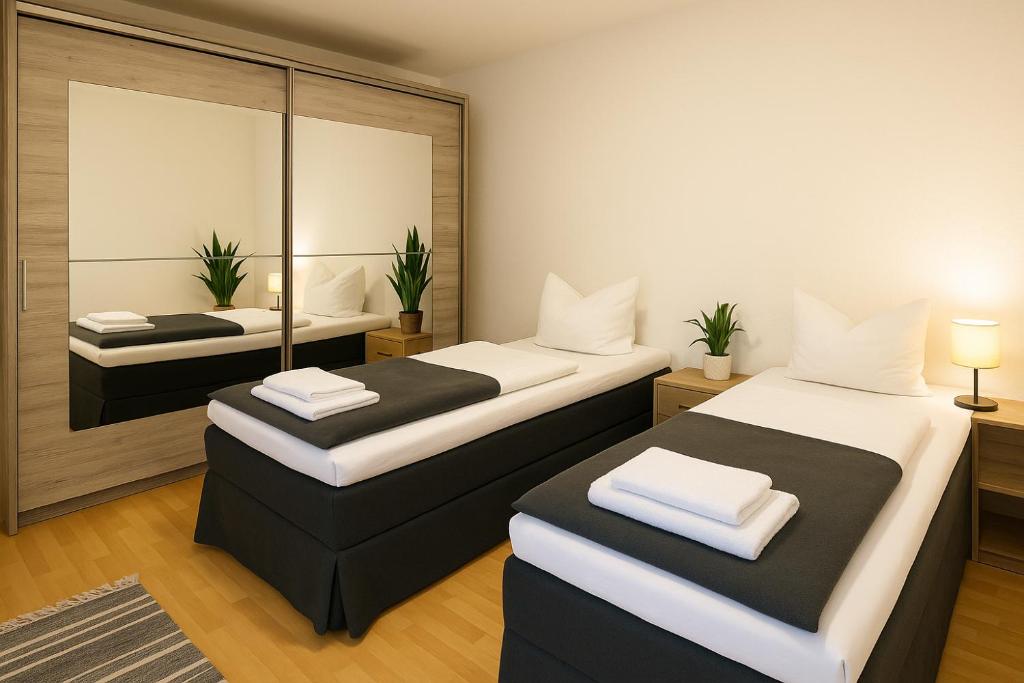 ein Zimmer mit zwei Betten und einem Spiegel in der Unterkunft SUNNYHOME Monteurwohnungen und Apartments nahe Regensburg in Nittendorf