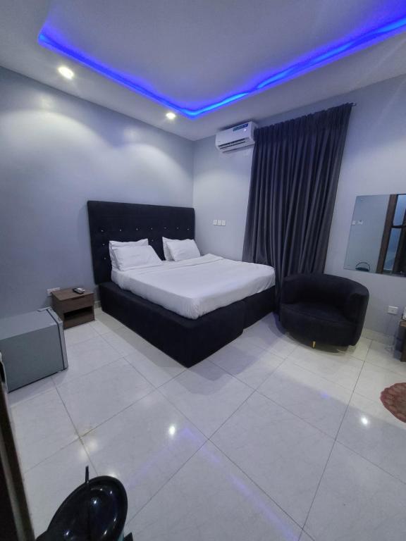 Un dormitorio con una cama y una silla negra. en Danamic view hotel, en Abuja