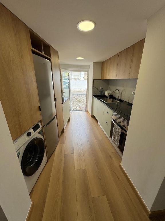 une grande cuisine avec un lave-linge et un sèche-linge. dans l'établissement Casa Catalão, à Montelavar