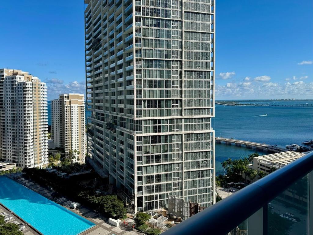 Un edificio alto con piscina frente a una ciudad. en Stylish 1B Icon Brickell 25th fl Pool Spa Gym Parking, en Miami