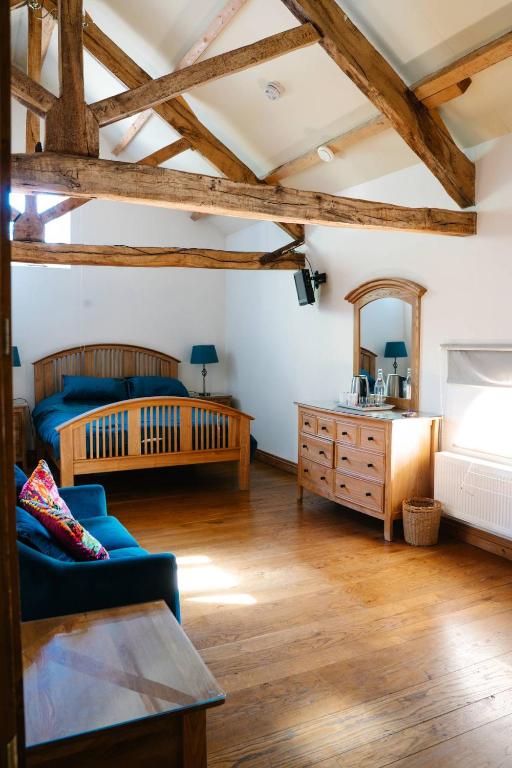 a bedroom with a bed and a couch and a mirror at Henllys Estate B and B in Llandovery