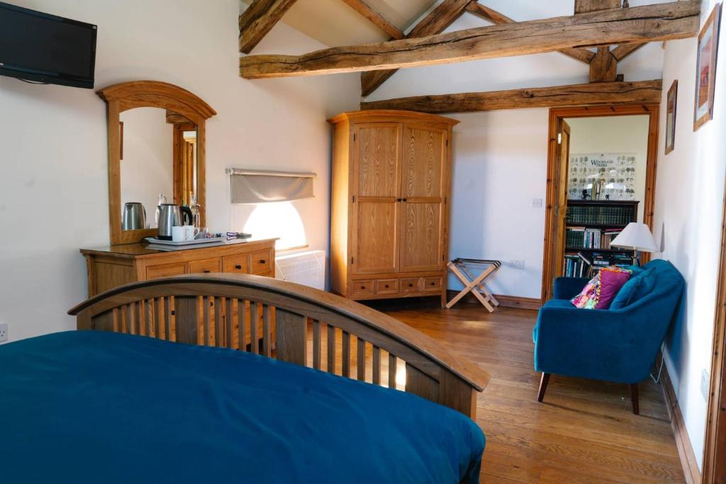 a bedroom with a bed and a blue chair in a room at Henllys Estate B and B in Llandovery