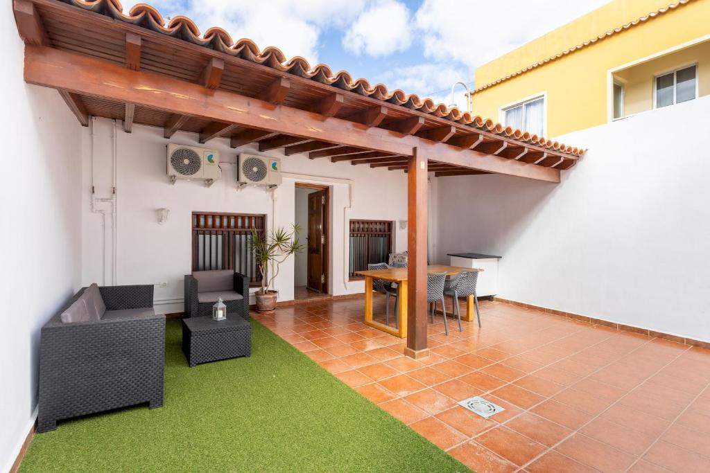 a patio with a pergola and a table and chairs at Home2Book Family House with Terrace in Las Maretas in La Mareta
