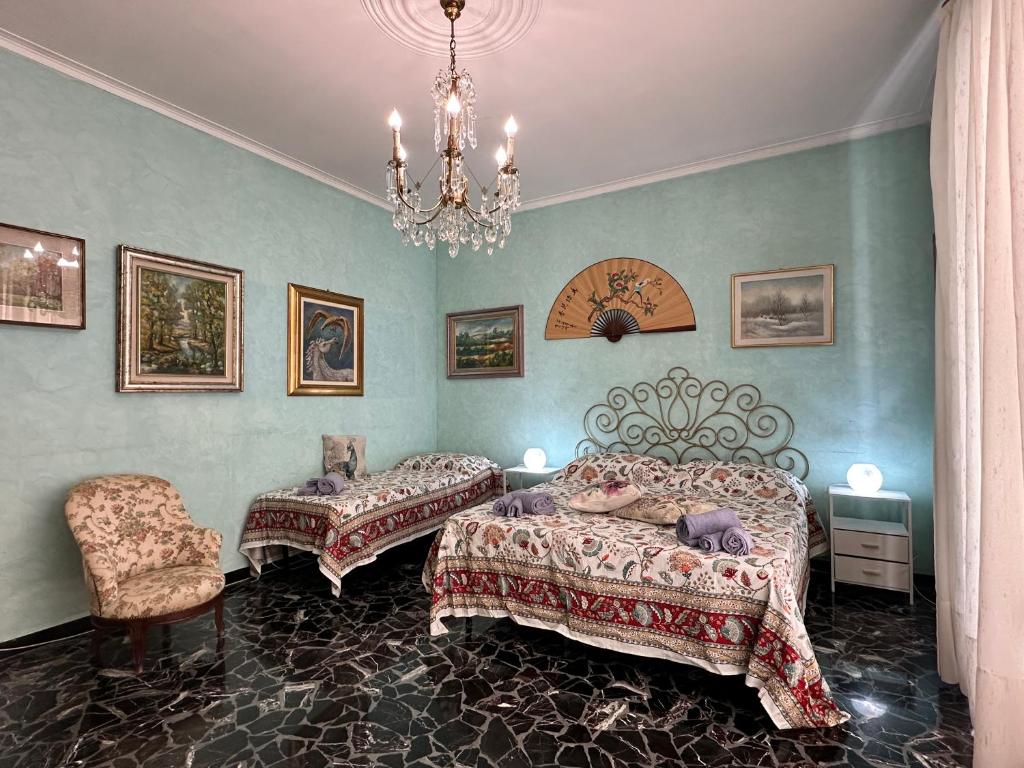Un dormitorio con dos camas y una lámpara de araña. en Amarcorde Home in Corso Buenos Aires con 6 posti letto, en Chiavari