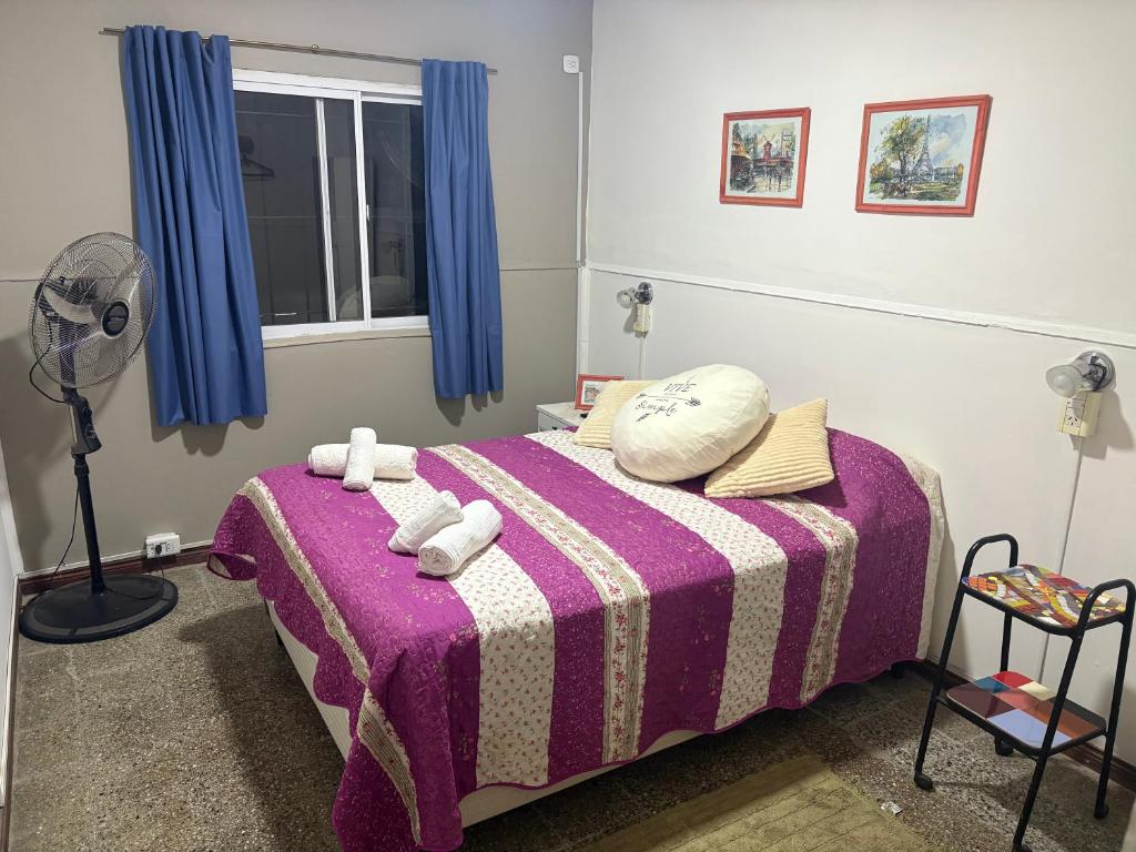 a bedroom with a bed with a purple blanket at "La Violeta" casa con jardín y cochera, San Pedro in San Pedro