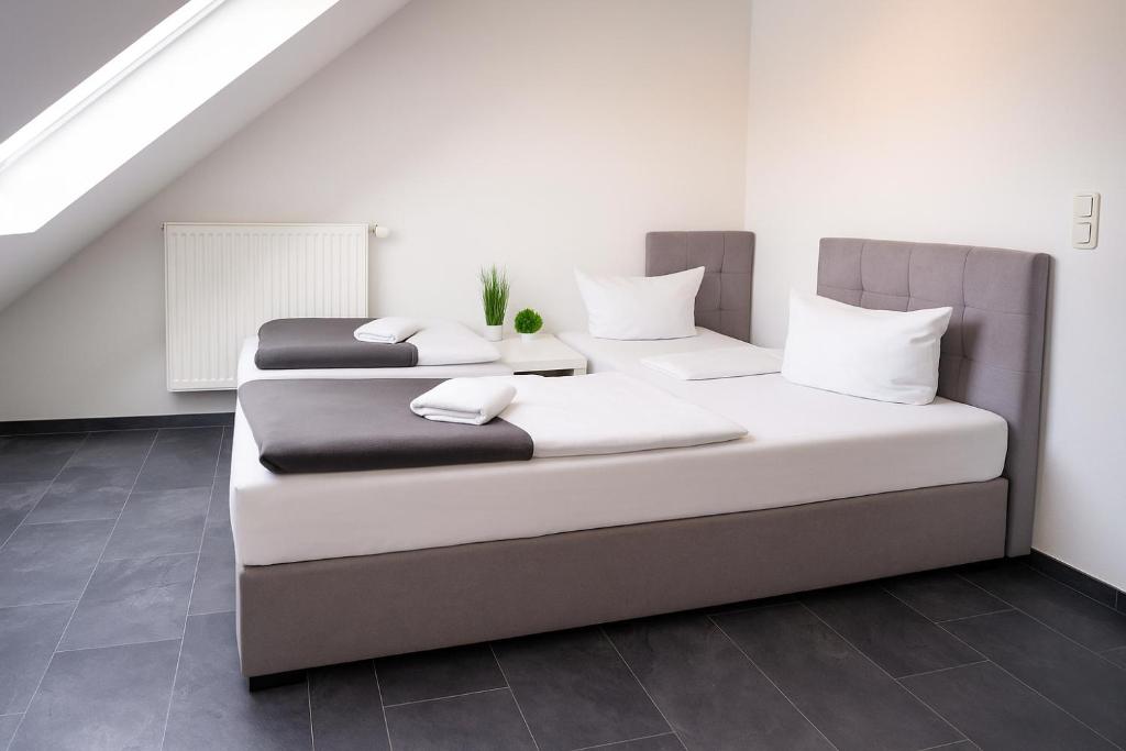 two beds in a room with white walls at SUNNYHOME Monteurwohnungen und Apartments nahe Regensburg in Obertraubling