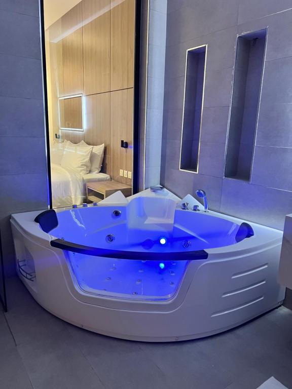 a large white bath tub in a room with a bed at فندق دبليو سويتس القنفذة in Al Qunfudhah