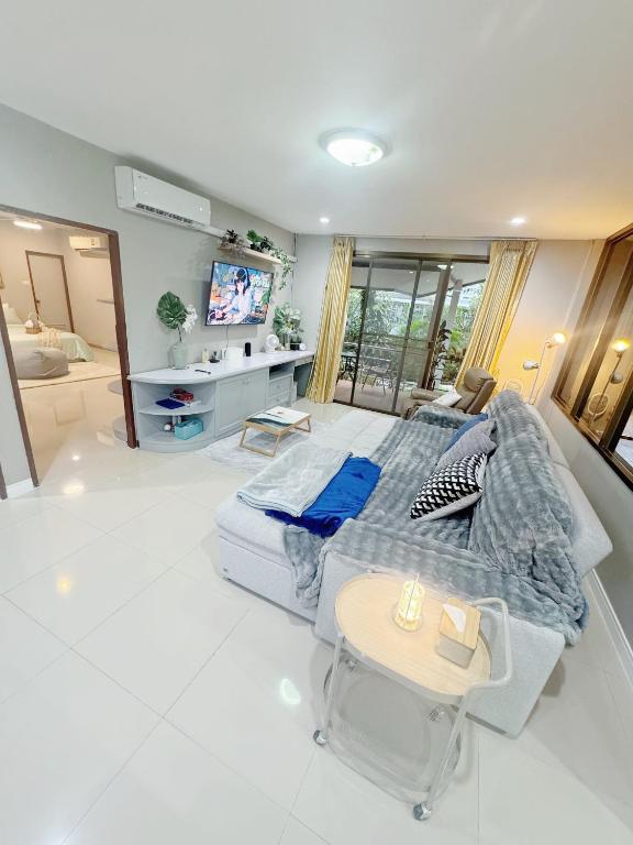 een slaapkamer met een groot bed en een televisie bij Sun and Moon House in Pattaya