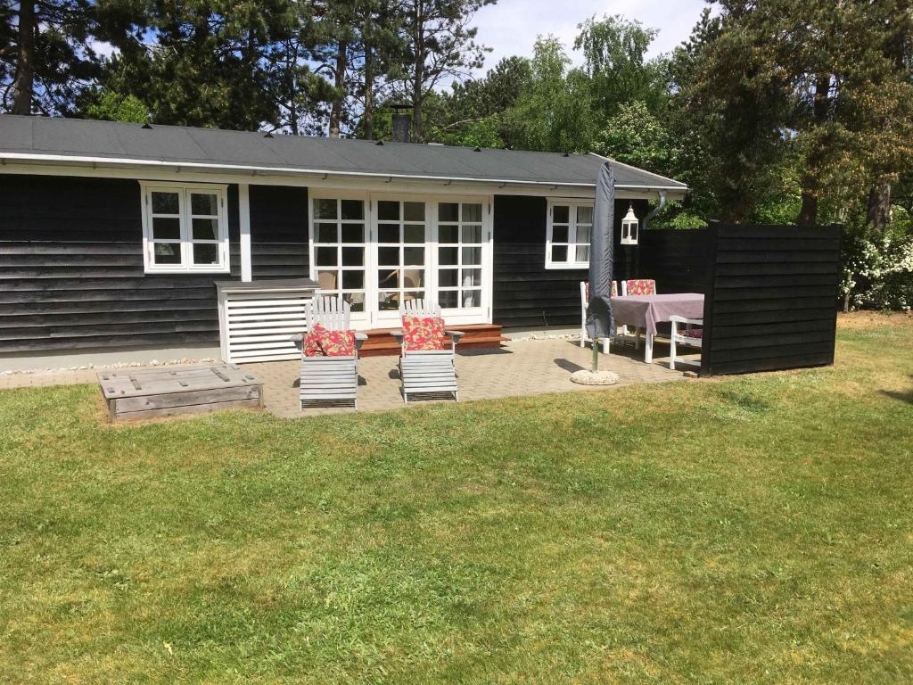 a house with two chairs and a table in the yard at Child-Friendly Holiday 500 Meters From The Beach in Nykøbing Sjælland